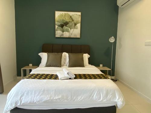a bedroom with a large bed with green walls at KL East The Ridge in Kuala Lumpur