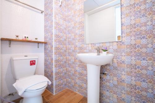 a bathroom with a toilet and a sink at Sweetloft Hotel Don Muang in Bangkok