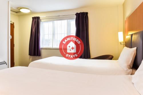 a hotel room with two beds and a window at Tyger Inn Derby in Derby