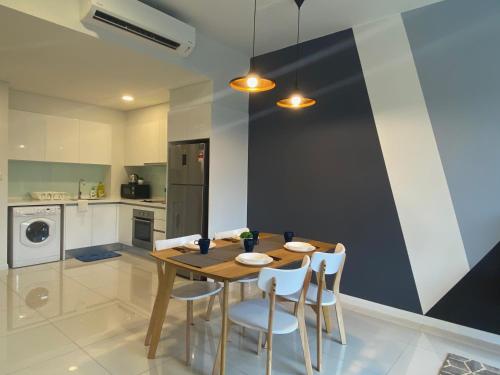 a kitchen with a wooden table and white chairs at KL East The Ridge in Kuala Lumpur