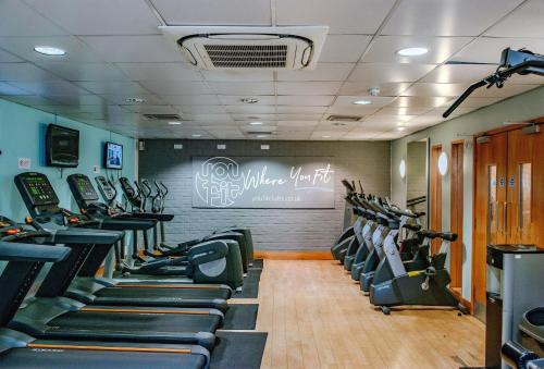 a gym with rows of treadmills and elliptical machines at Holiday Inn Ipswich by IHG in Ipswich