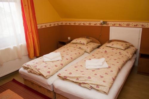 two beds sitting next to each other in a bedroom at Erdős Vendégház in Jánossomorja