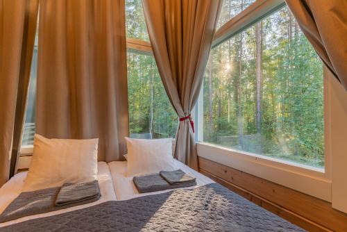 a bedroom with a bed and a large window at Saimaa Life Apartments in Imatra
