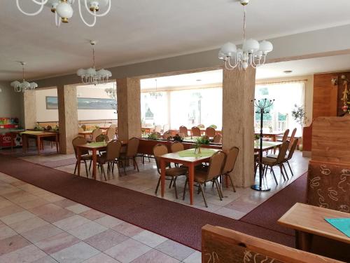 Bungalovy pri Hoteli Spojar في زيار: غرفة طعام مع طاولات وكراسي ونوافذ