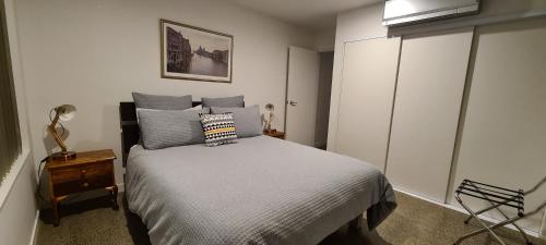 a bedroom with a bed with blue pillows at The Kingsland Suite in Auckland