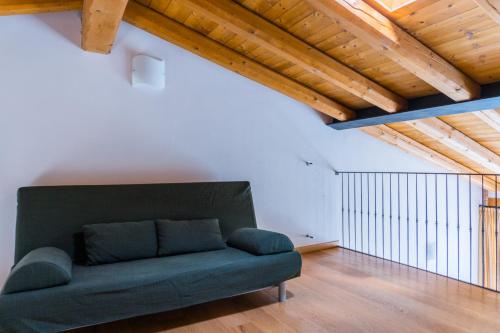 a green couch in a room with wooden ceilings at Agriturismo Dai Gobbi in Fara Vicentino