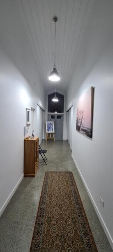 a hallway with white walls and a table and a rug at The Kingsland Suite in Auckland