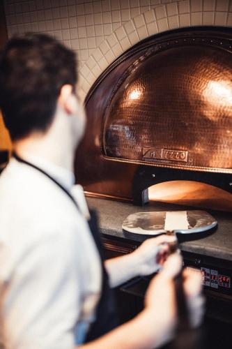 a man standing in front of an oven at Lily Country Club in Klofta