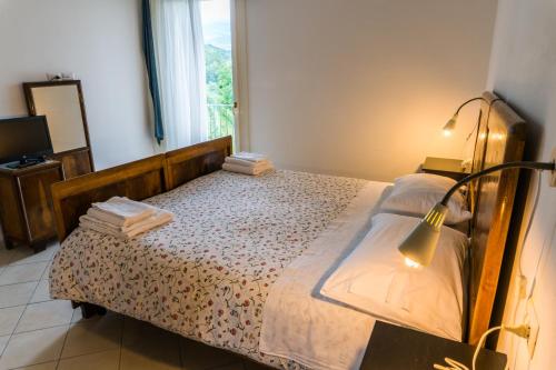 a bedroom with a bed with a lamp and a window at Agriturismo Dai Gobbi in Fara Vicentino