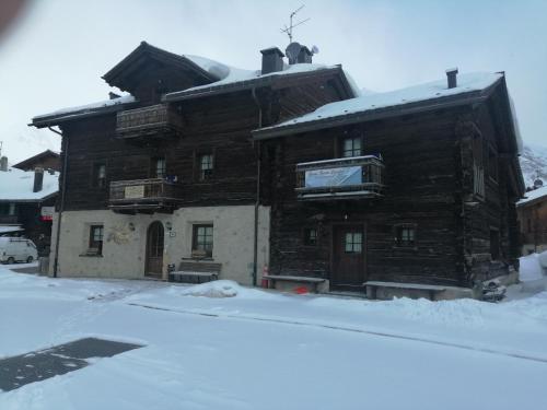 a large building with a snow covered roof at Garni Baita Cecilia in Livigno