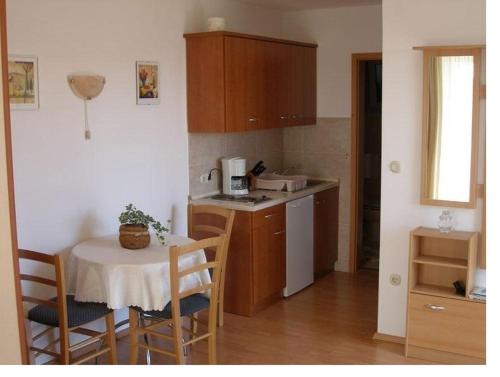 eine kleine Küche mit einem Tisch, einem Tisch und Stühlen in der Unterkunft Studio Apartment in Mošćenička Draga with Sea View, Balcony, Air Conditioning, Wi-Fi (4772-2) in Mošćenička Draga