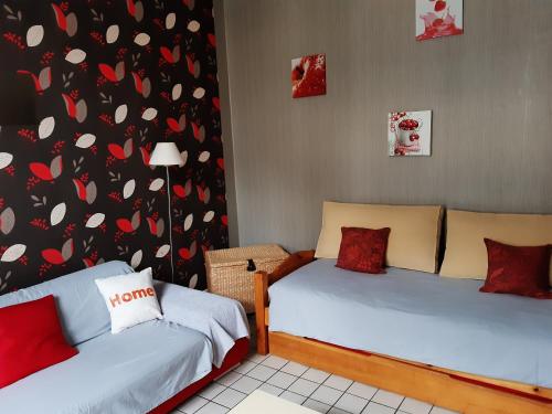 - 2 lits dans une chambre avec des cœurs sur le mur dans l'établissement Gite "Etape à Coucy", à Coucy-le-Château-Auffrique
