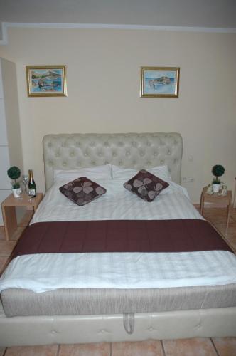 a bedroom with a large bed with two pillows on it at Guest House Maja in Novi Sad