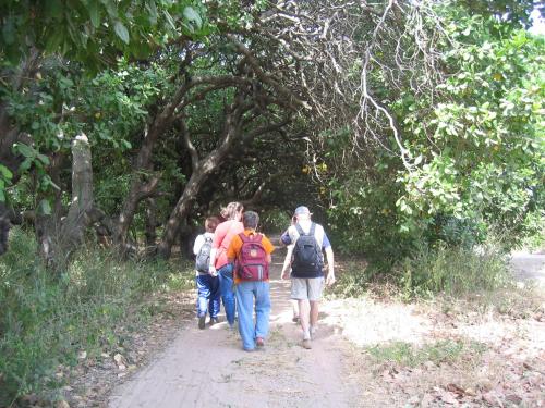 a group of people walking down a dirt trail at Kansala Ta Toto in Kafountine