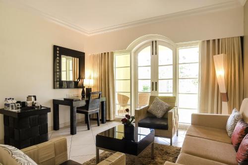 a living room with a couch and a table and a piano at The Zuri White Sands, Goa Resort & Casino in Varca
