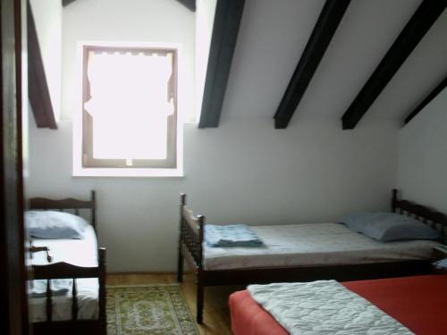 a bedroom with two beds and a window at Apartment in Zlarin with balcony, W-LAN, washing machine (3813-1) in Zlarin