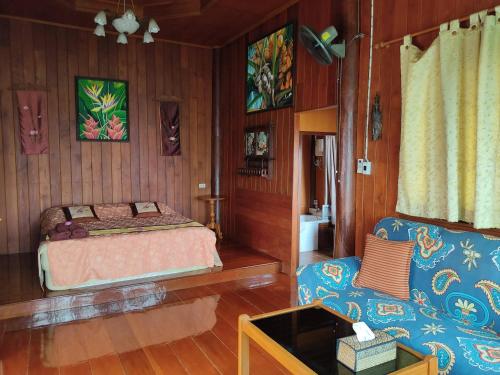 a bedroom with a bed and a couch at Hidden Holiday House in Ban Don Faek