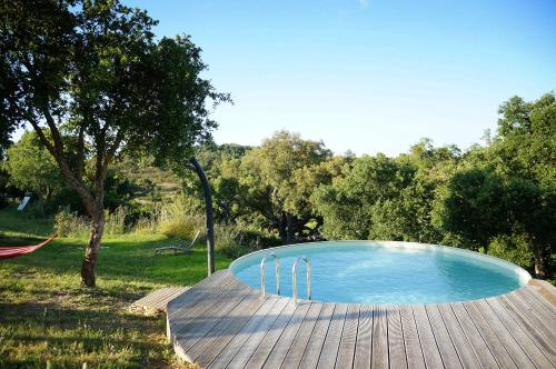 a swimming pool on a wooden deck in a field at MOBA - Monte do Barranquinho in São Luis