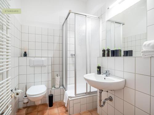 biała łazienka z toaletą i umywalką w obiekcie Apartment Berlin Paul-Robeson-Straße w Berlinie