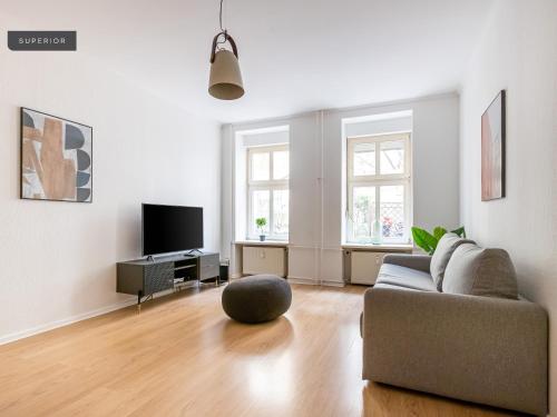 a living room with a couch and a television at Apartments Berlin Niederbarnimstraße in Berlin