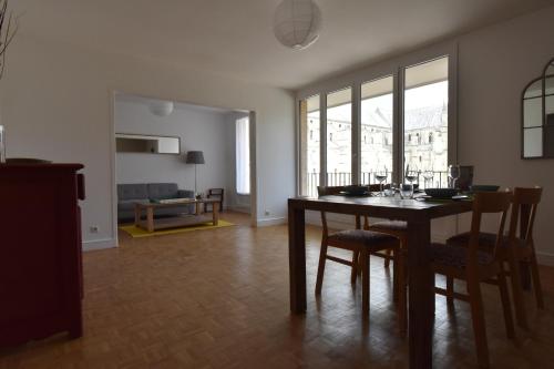 un salon avec une table et des chaises de salle à manger dans l'établissement Au Pied de la Basilique, à Reims