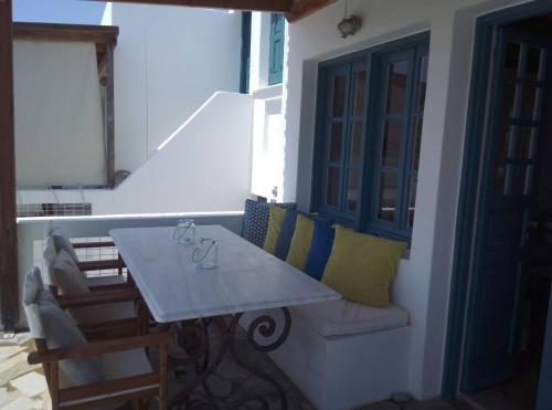 un tavolo bianco con sedie e un balcone con tavolo di Chez Semiramis Sunrise Serifos 11 persons a Rámos
