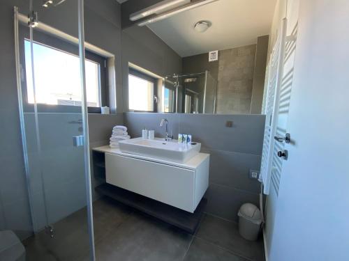 a bathroom with a sink and a glass shower at The View Luxury Residence with Pool in Zadar
