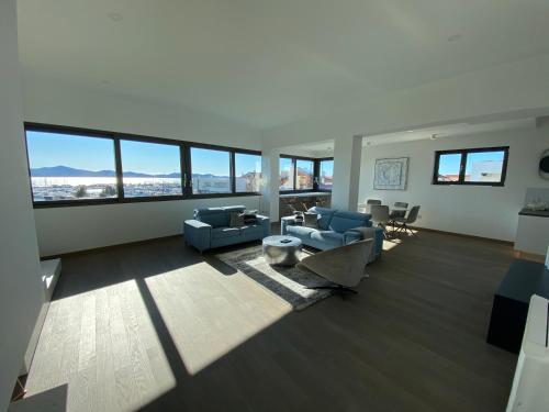 a large living room with blue couches and windows at The View Luxury Residence with Pool in Zadar