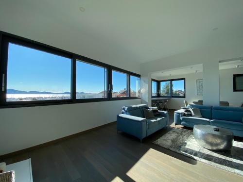 a living room with blue furniture and large windows at The View Luxury Residence with Pool in Zadar