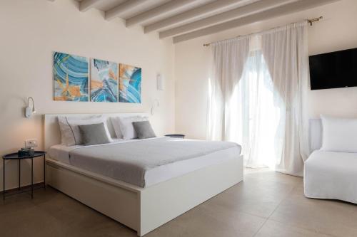 Un dormitorio blanco con una cama grande y una ventana. en South Key Villa, en Pefki