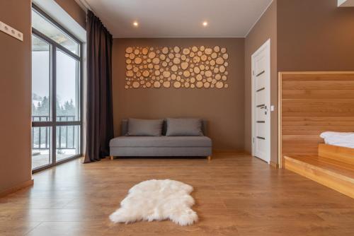 sala de estar con sofá y alfombra blanca en Chillax en Bukovel