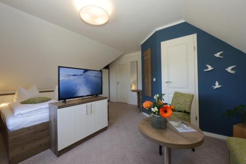 a bedroom with a tv and a bed and a table at Gasthof "to`n Eikbom" in Dargen