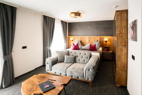 Habitación de hotel con sofá y cama en Waidringer Hof 4 Sterne Superior, en Waidring