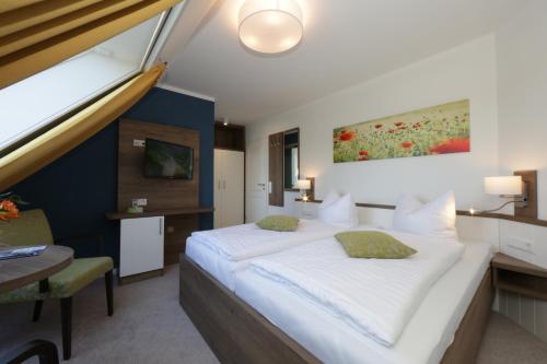 um quarto de hotel com uma cama grande e uma secretária em Gasthof "to`n Eikbom" em Dargen
