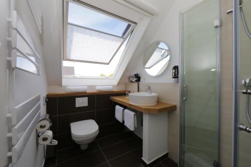 baño con aseo y lavabo y ventana en Gasthof "to`n Eikbom" en Dargen