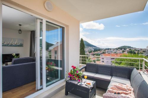 a balcony with a couch and a view of a city at Apartment Navis in Dubrovnik