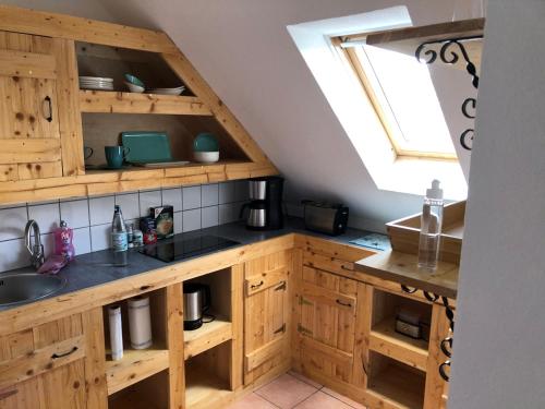 a kitchen with wooden cabinets and a sink at Appartements Papillon in Gevelsberg