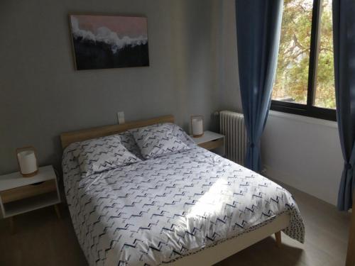 ein Schlafzimmer mit einem Bett und einem Fenster in der Unterkunft BEL APPARTEMENT TYPE F3 in Amélie-les-Bains-Palalda