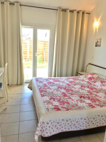 - une chambre avec un lit doté d'une couverture fleurie dans l'établissement Le Maset en Camargue, à Saintes-Maries-de-la-Mer