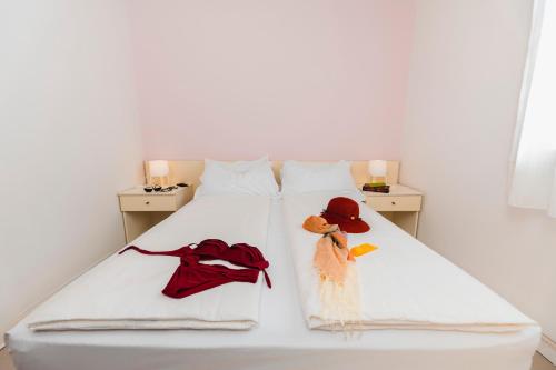 a white bed with hats and towels on it at Natural Village Resort in Porto Potenza Picena