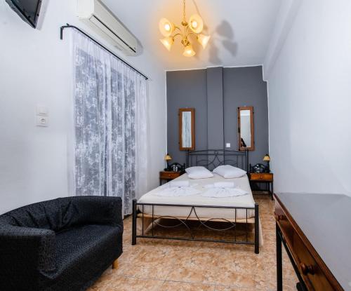 a bedroom with a bed and a chair at Villa Toula in Fira