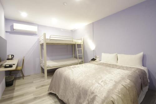 a bedroom with a bed and a bunk bed at WE Hotel in Miaoli