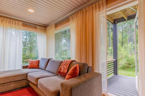 a living room with a couch and large windows at Saimaa Life Apartments in Imatra