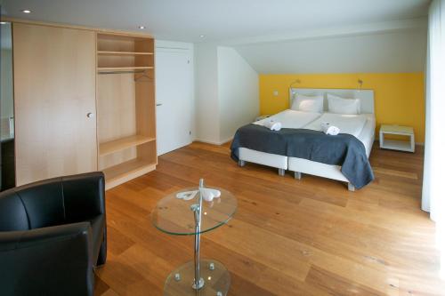 a bedroom with a bed and a glass table at Landgasthof Zollhaus in Sachseln