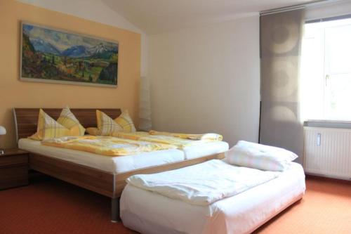 a bedroom with two beds and a painting on the wall at Ferienwohnung Krittian in Teisendorf