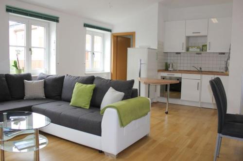 a living room with a couch and a kitchen at Ferienwohnung Krittian in Teisendorf