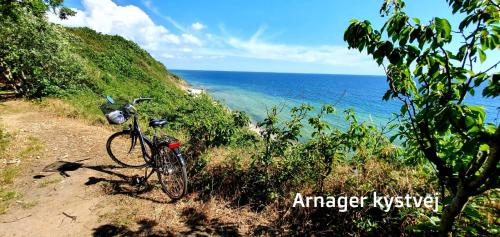 a bike parked on a dirt road next to the ocean at The Cherry Apartment - 'Den Gule Svane' Guest House near Rønne & Beach in Rønne