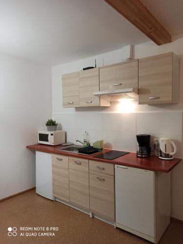 a kitchen with white cabinets and a red counter top at Pokoje Gościnne Izabela in Szklarska Poręba