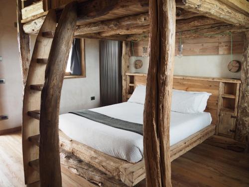 ein Schlafzimmer mit einem hölzernen Etagenbett mit weißen Laken in der Unterkunft Virasol in Dronero