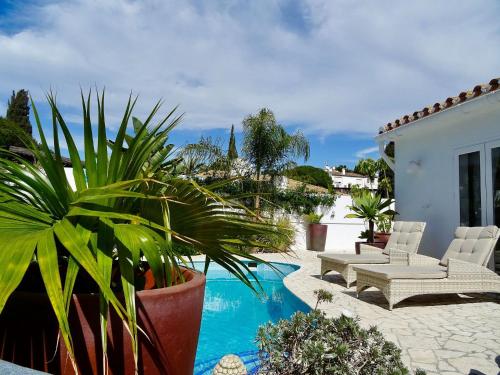 a patio with a pool and chairs and plants at VILLA OASIS SEA VIEW 3 bed PRIVATE HEATED POOL - La Cala de Mijas by Solrentspain in Mijas Costa